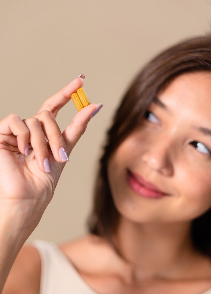 Woman holding a supplement capsule